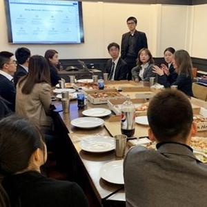 Student sit around a conference table talking and listening to a presentation