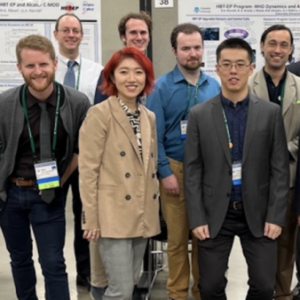 A group of students stand in front of research posters at a conferrence