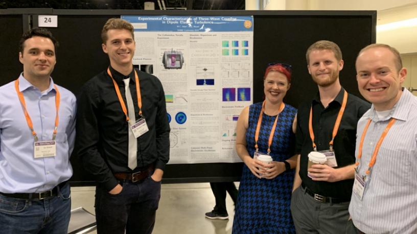 Columbia University students standing around a poster at the APS workshop