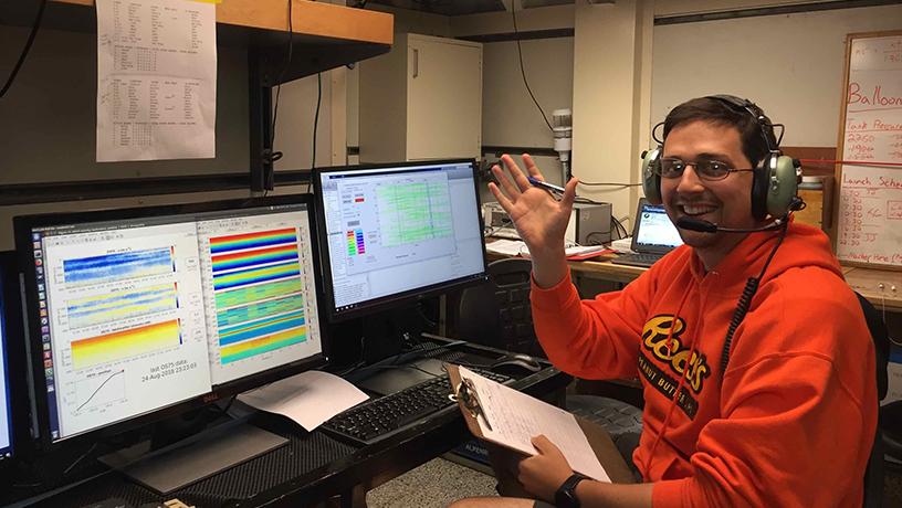 Zane Martin working at computers aboard the ship