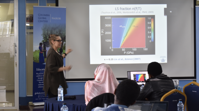 A photo of Renata Wentzcovitch standing in front of the lecture room and talking to conference participants