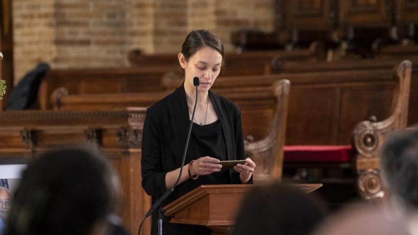 Beatrix Chu stands at the podium and reads a eulogy and poem.