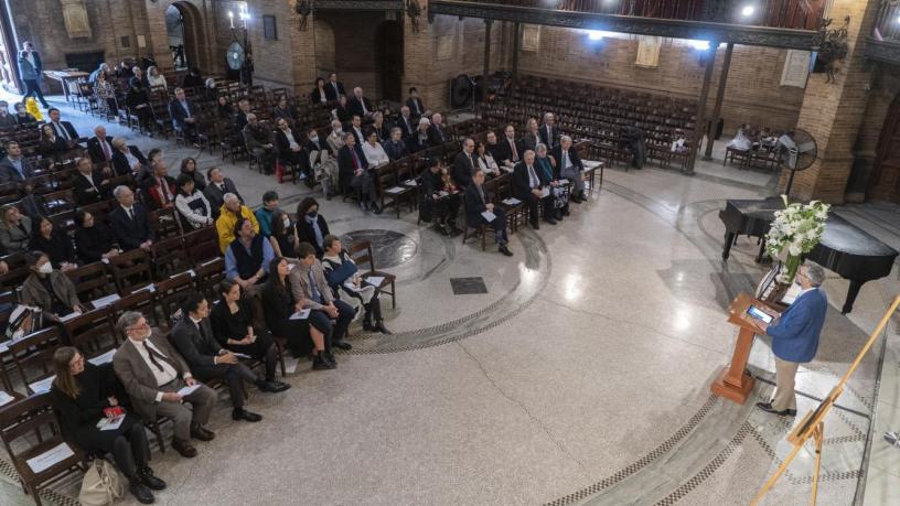 Photo of people sitting in a chapel facing a speaker at a podium