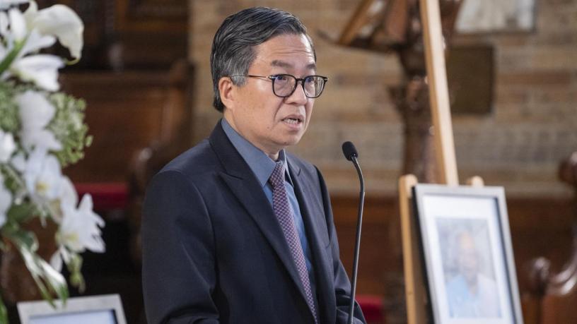 A photo of Dean Shih-Fu Chang. He is wearing a blue suit and tie and is standing at a podium in the front of a chapel