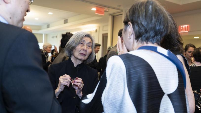 People stand at a reception and are talking.