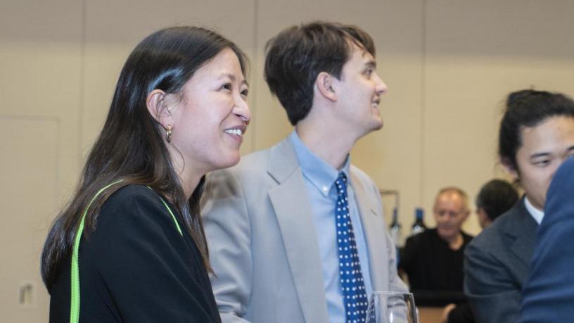 People stand at a reception and are talking and smiling.