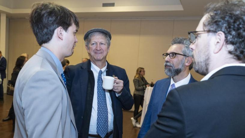 People stand at a reception and are talking and smiling.