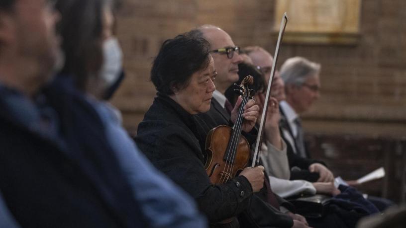 A photo of Dr. Yeou-Cheng Ma sitting and holding a violin