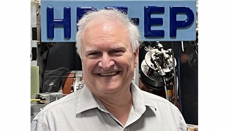 A photo of Professor Gerald Navratil. He is standing in front of an experiment and smiling.