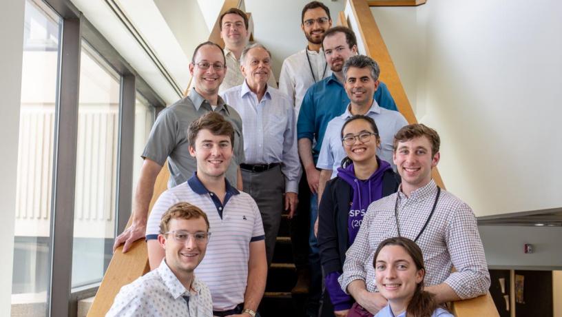 Photo of 11 people standing on a staircase. They are mixture of faculty, students, and researchers, both male and female.