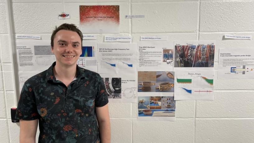 A student stands in front of their research project