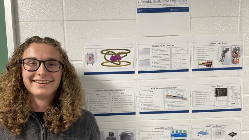 A student stands in front of their research project