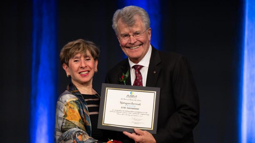 A photo of a woman accepting an award certificate from a man