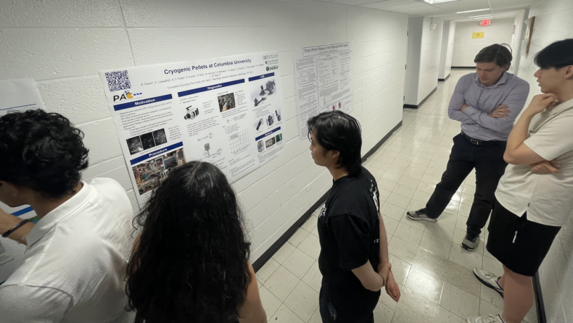 Students stand in front of a research poster