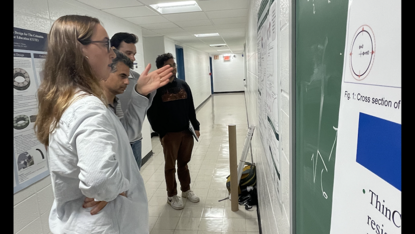 Students stand in front of a research poster