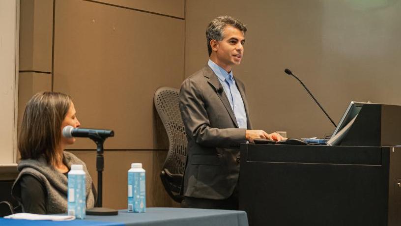 a man stands at a podium and speaks into a microphone