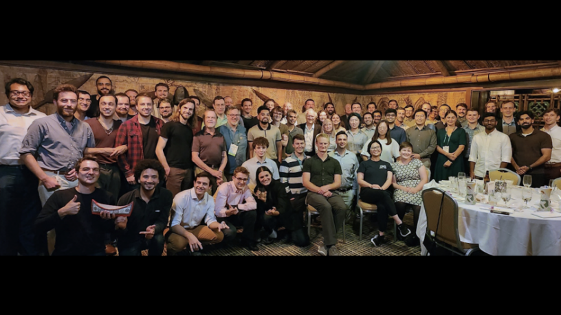 a very large group of people pose for a photo in a restaurant
