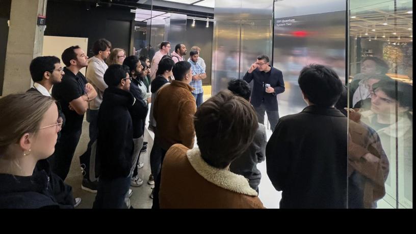 A group of students stand inside in a lab