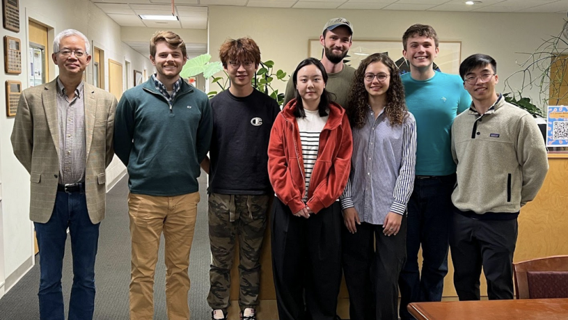 A group of students stand inside an office