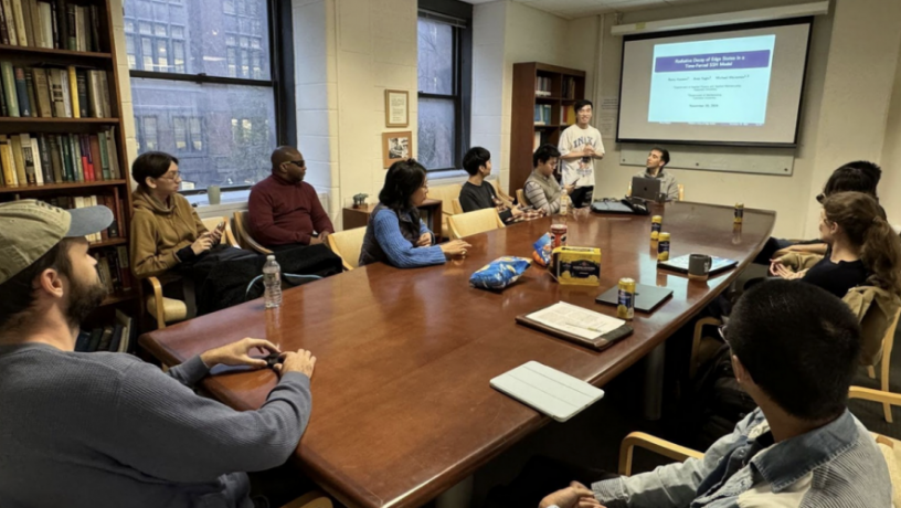 A group of students sit around a conference room table