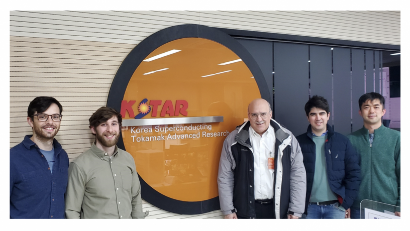a group of men standing in front of a Kstar logo