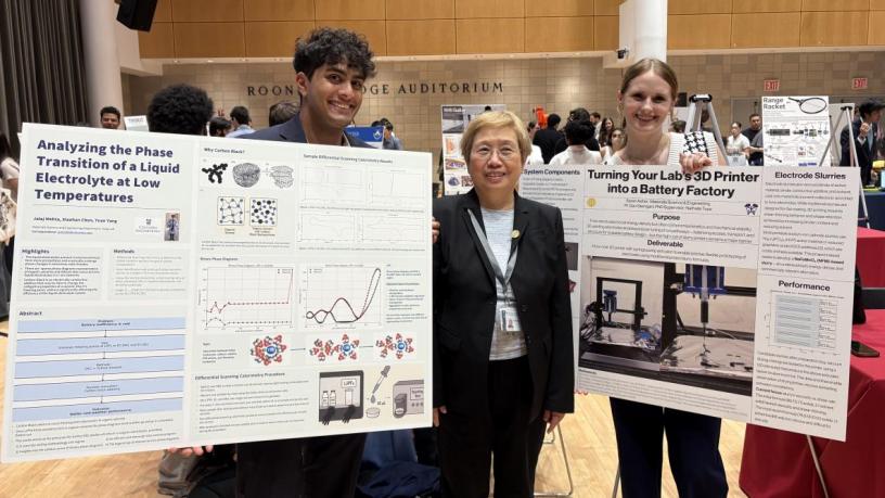 two students and a faculty member in front of research posters