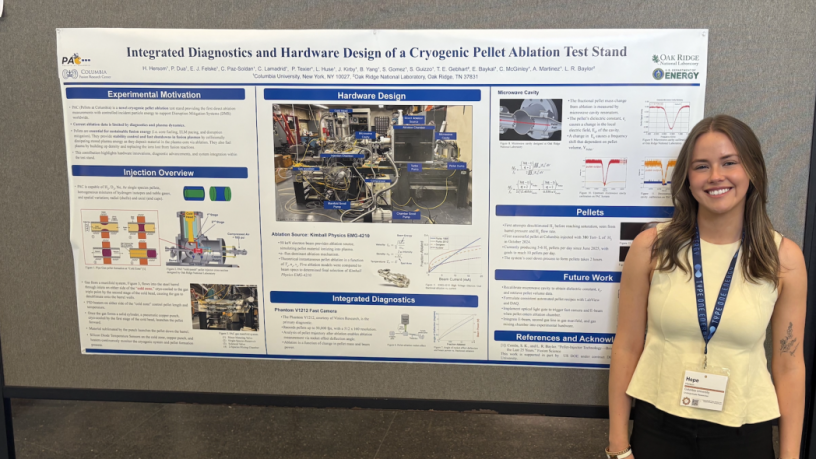 A student standing in front of a research poster