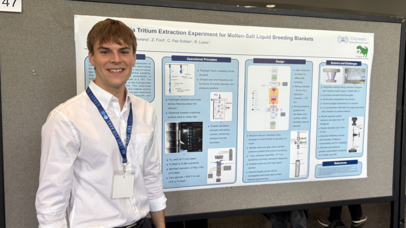 A student standing in front of a research poster
