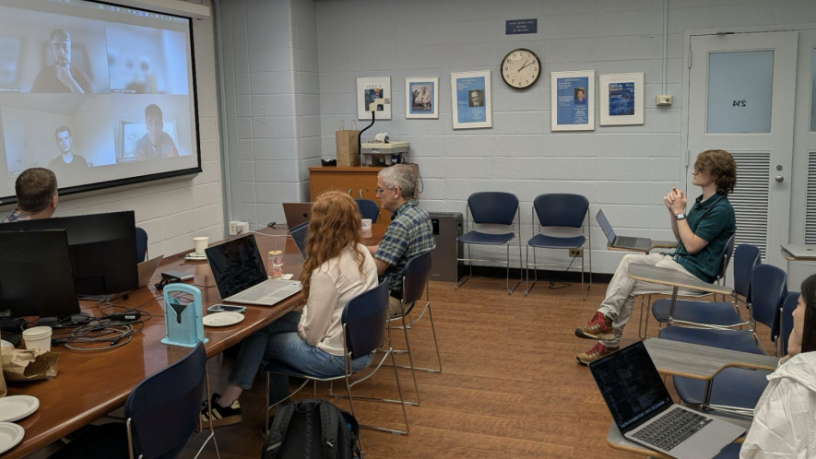 a group of student in a classroom looking at a Zoom screen