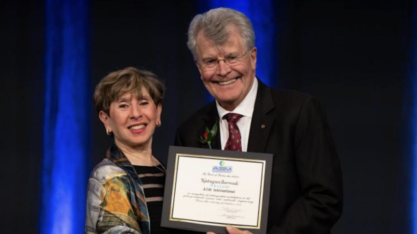 photo of a woman receiving an award from a male presenter