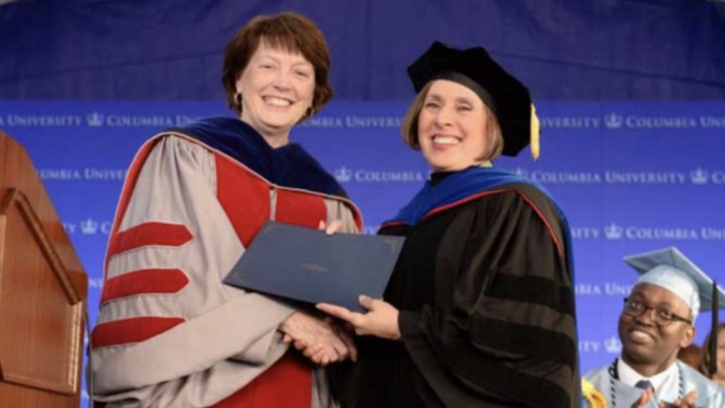 A woman presenting an award to another woman