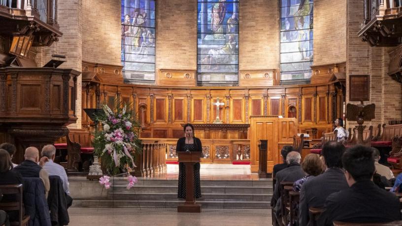 a photo of a woman at a podium in a chapel