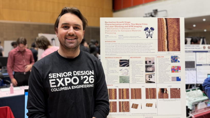 student standing in front of a poster