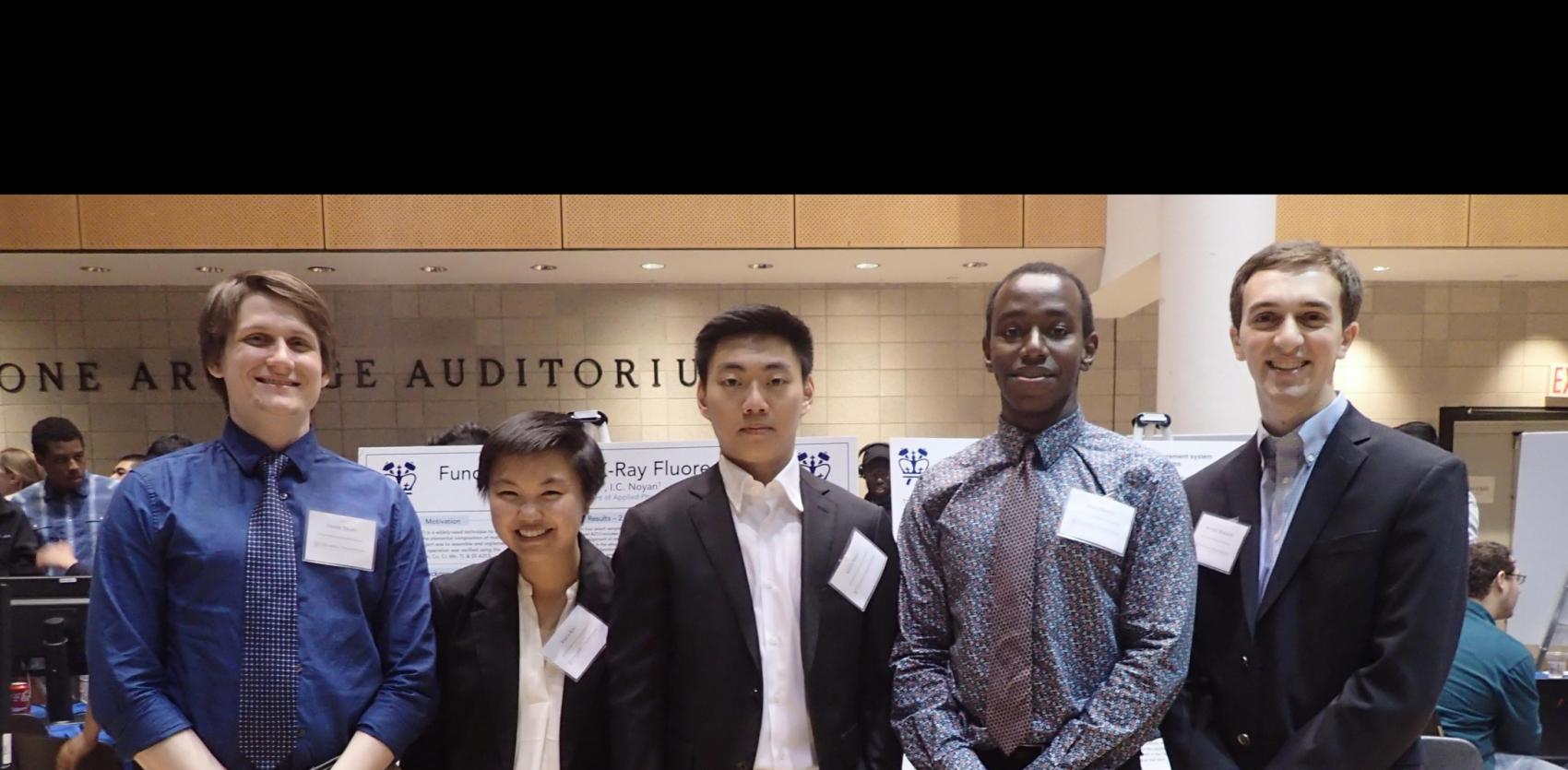 Five students standing infront of their poster presentations 