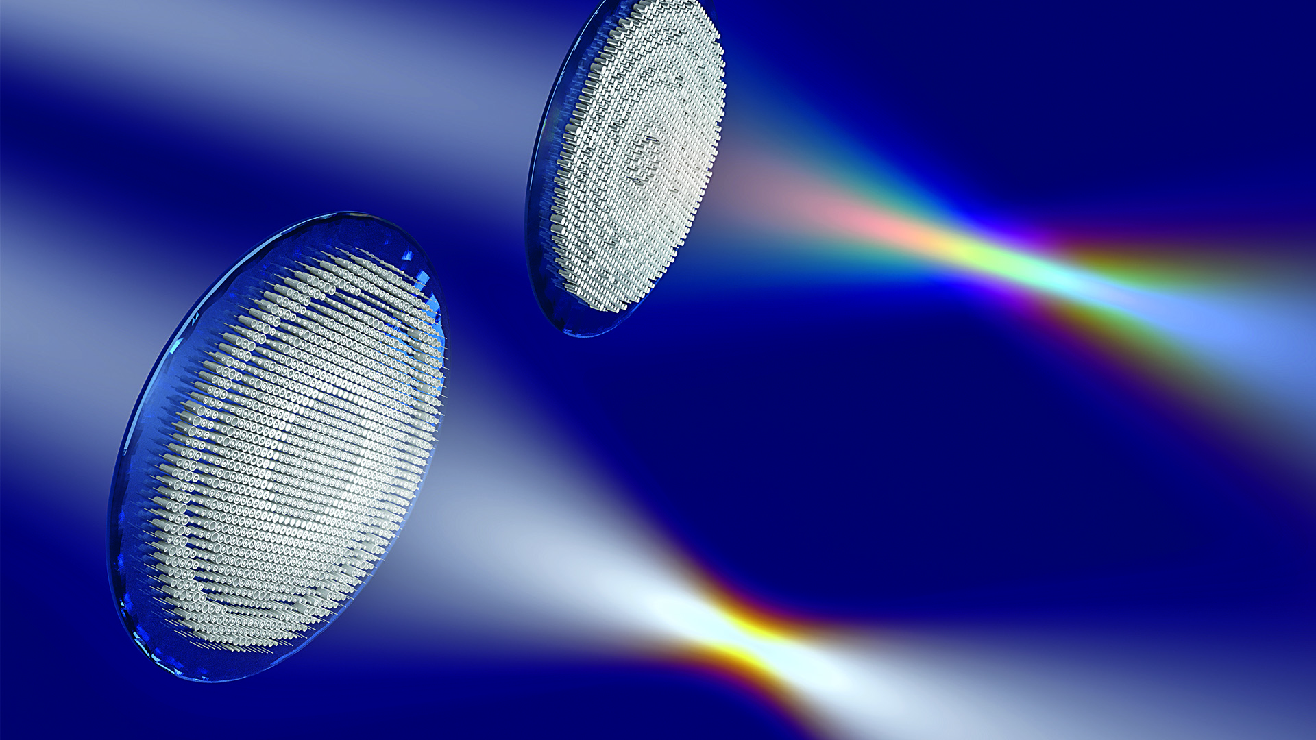 Two circular diffraction gratings with blue rims positioned against a blue gradient background, dispersing white light into a full spectrum rainbow ranging from violet to red, demonstrating optical diffraction and light dispersion.