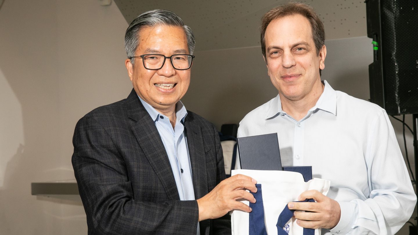 Gil Zussman and Dean Shih-Fu Chang hold a tote bag together.