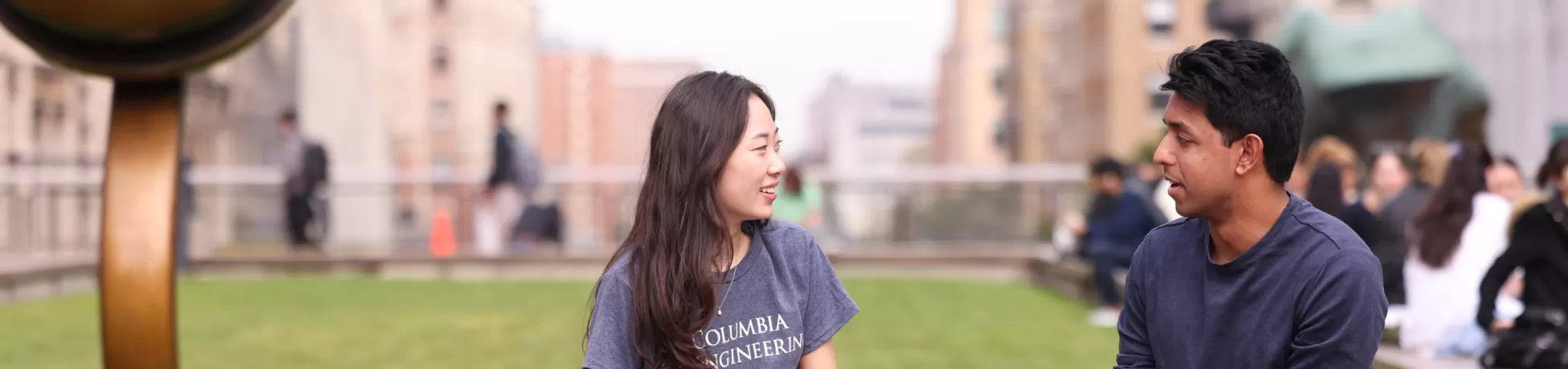 A student talks to an Admissions rep on the lawn at Columbia Engineering.