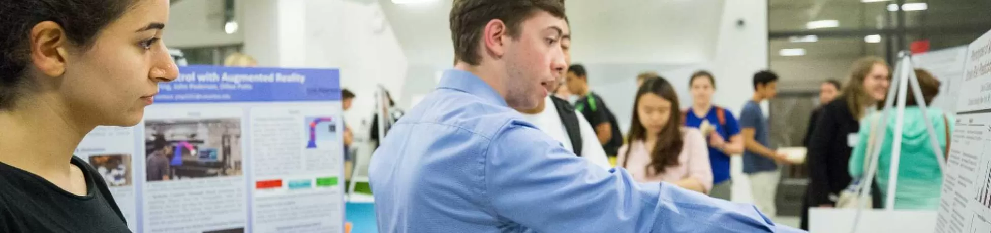 Student gesturing to a display in front of other students