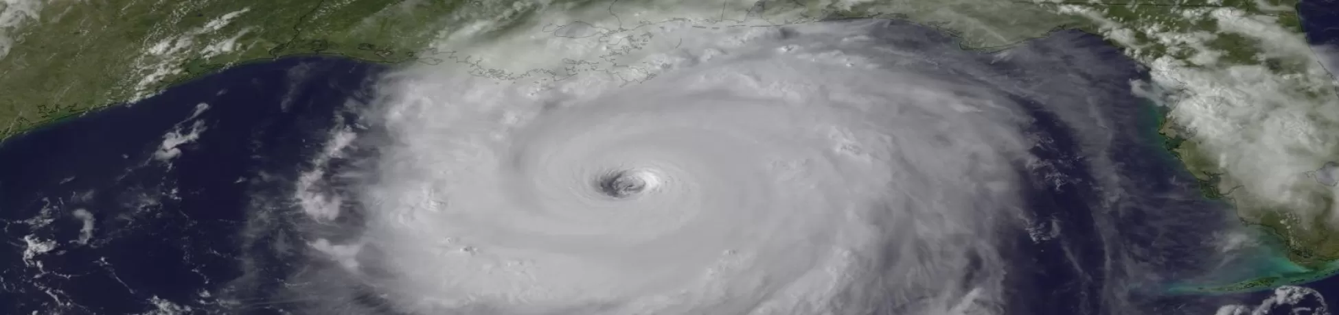 Satellite view of a large hurricane over the Gulf of Mexico, showing a well-defined eye and dense spiral cloud bands approaching the U.S. coastline.