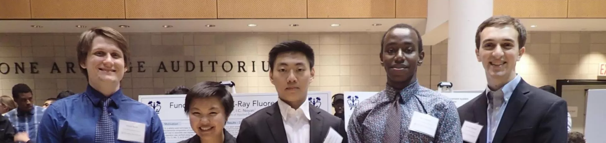 Five students standing infront of their poster presentations 