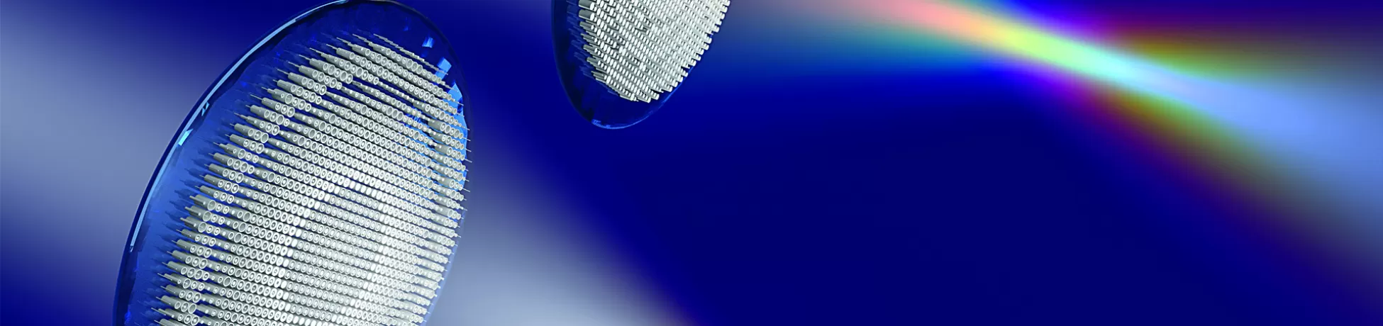 Two circular diffraction gratings with blue rims positioned against a blue gradient background, dispersing white light into a full spectrum rainbow ranging from violet to red, demonstrating optical diffraction and light dispersion.