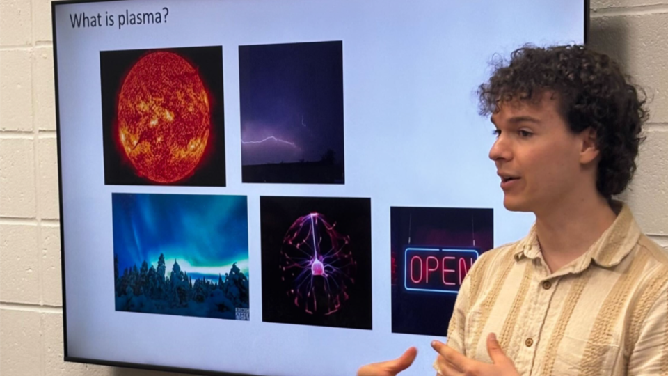 a student presents a talk in front of a presentation screen